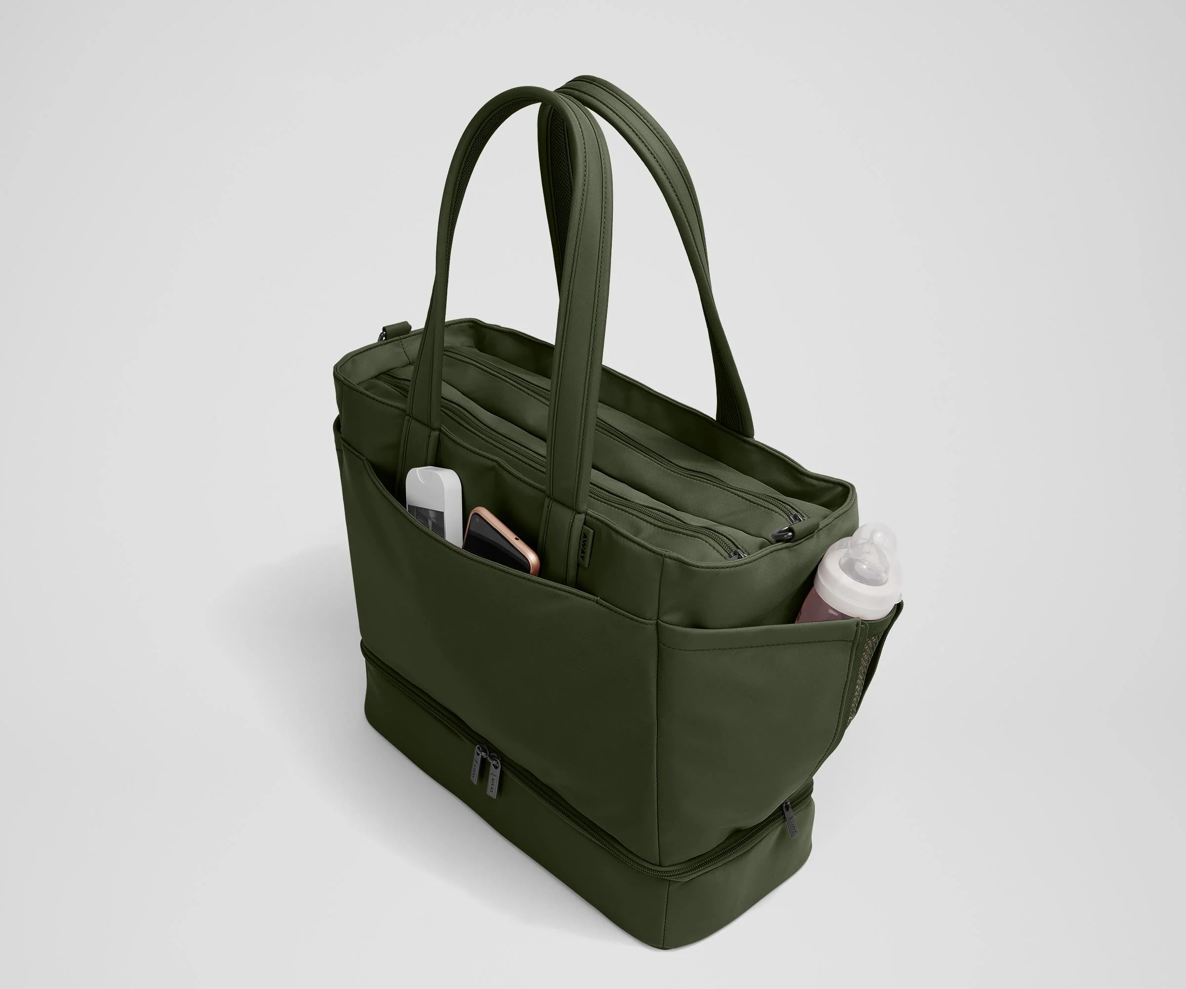 Exterior front pocket packed with hand sanitizer and a phone. Exterior bottle pocket packed with a milk bottle