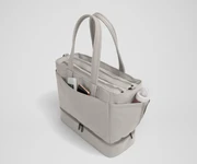 Exterior front pocket packed with hand sanitizer and a phone. Exterior bottle pocket packed with a milk bottle
