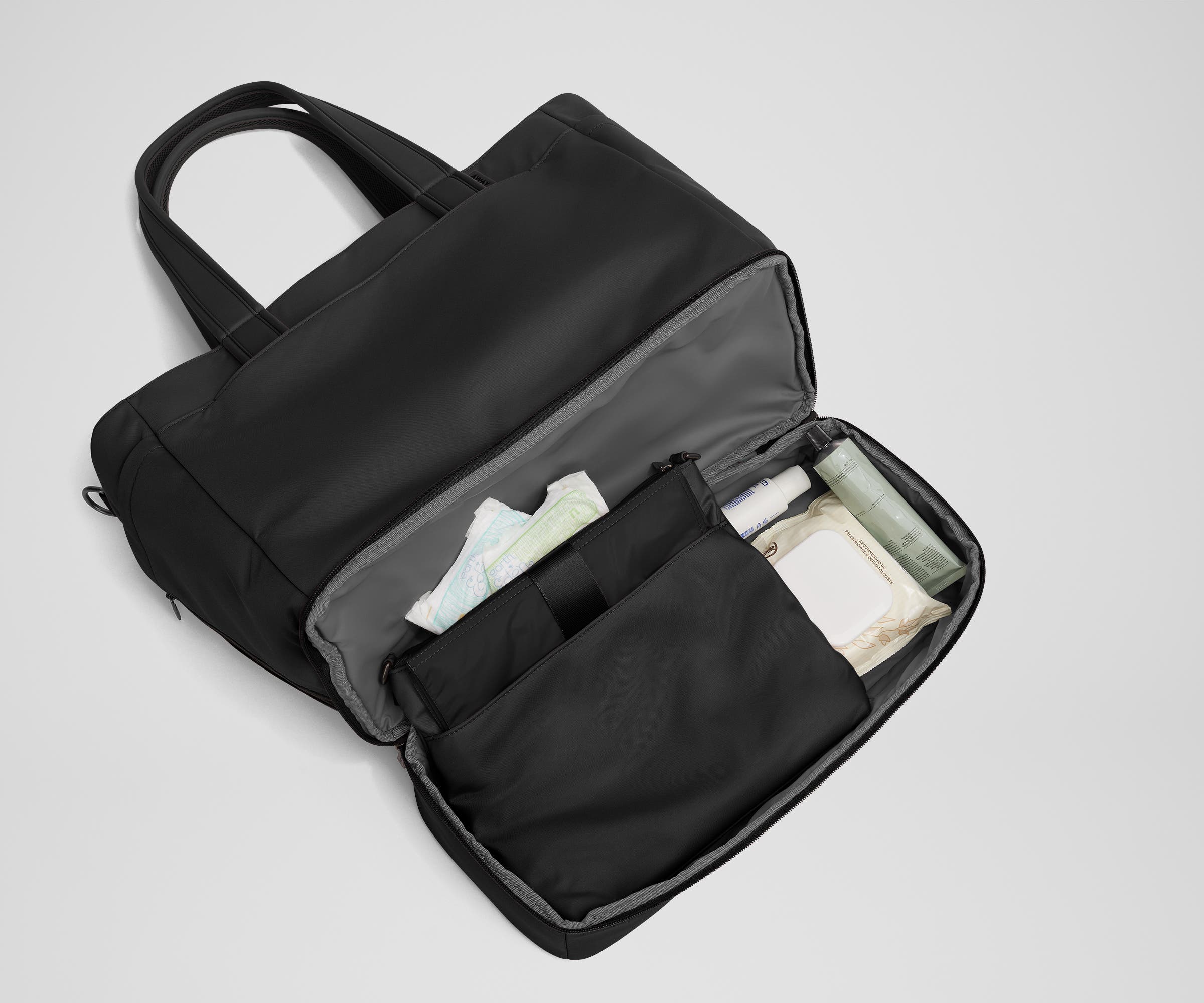Bottom compartment shown with the included changing pad and Carry-All pouch that fits diapers and wipes