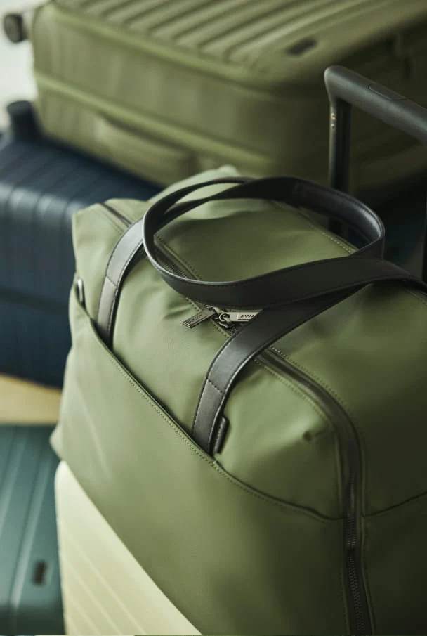Green duffel bag with a black strap 