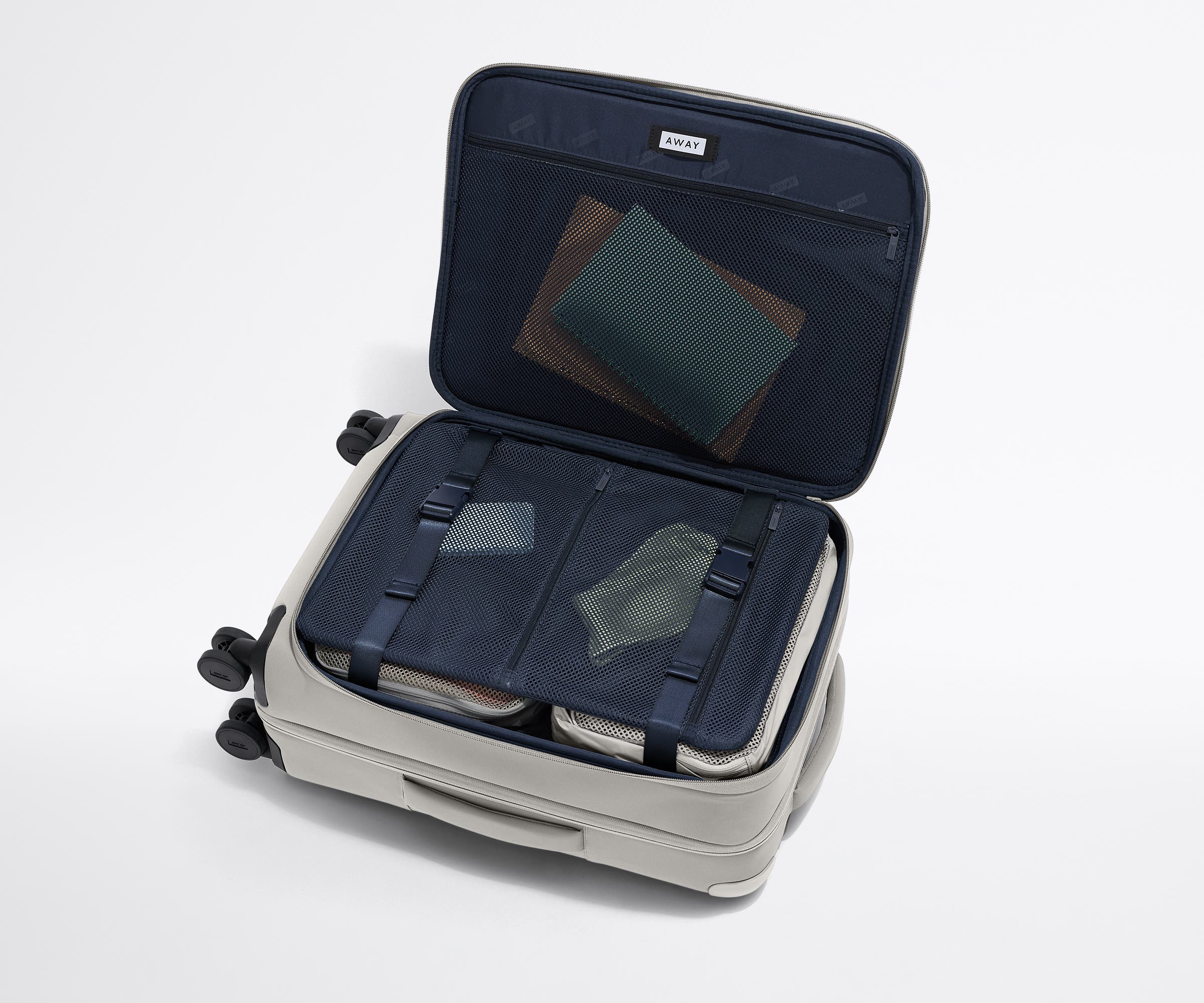 Open Softside Bigger Carry-On suitcase, with travel essentials in the front flap pocket and compression pad pockets