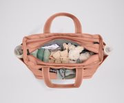 Front main compartment packed with child essentials, including a stuffed animal, wipes, and change of clothes
