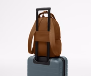 Featherlight Backpack on top of an Away suitcase, attached by the trolley sleeve
