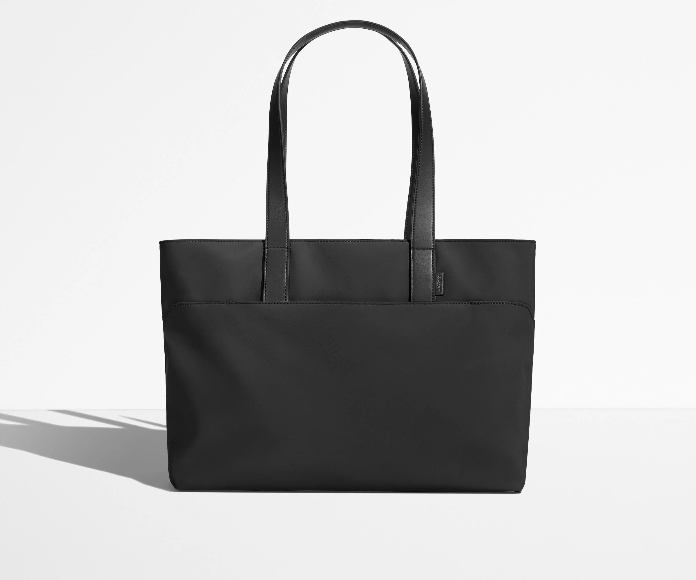 Front view of The Everywhere Tote with its leather handles up