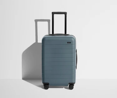 Front product view of The Carry-On suitcase in Coast Blue with raised handle