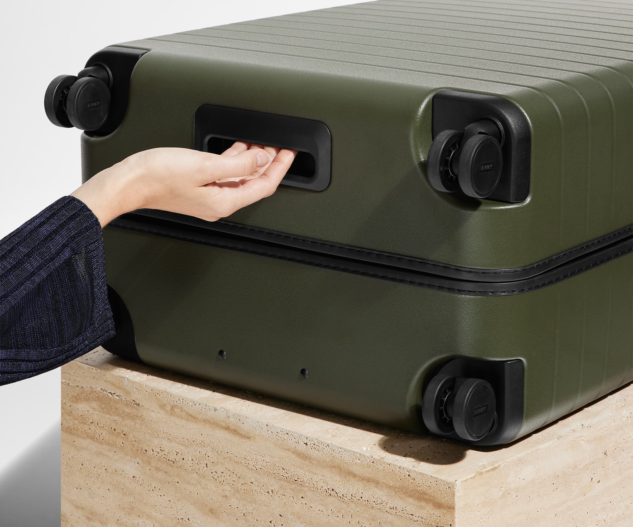 The Large suitcase in Olive Green shown from below highlighting the underside grab handle