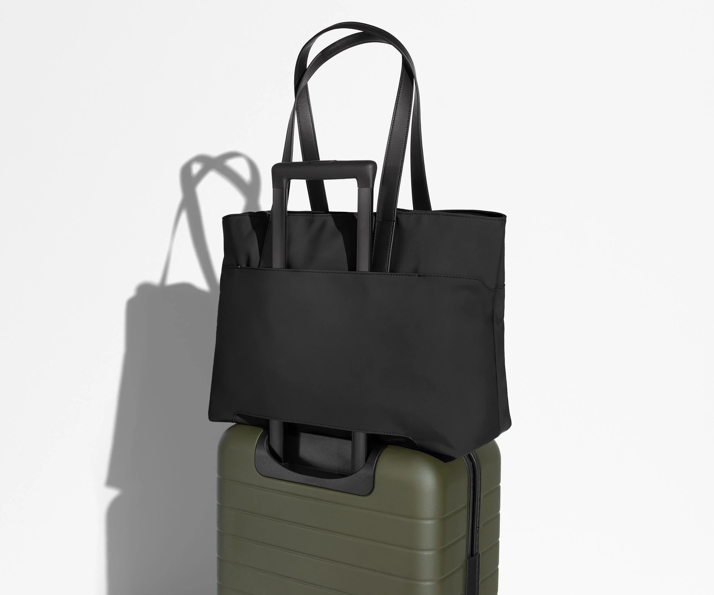 Everywhere Tote secured to an Away suitcase by its trolley sleeve