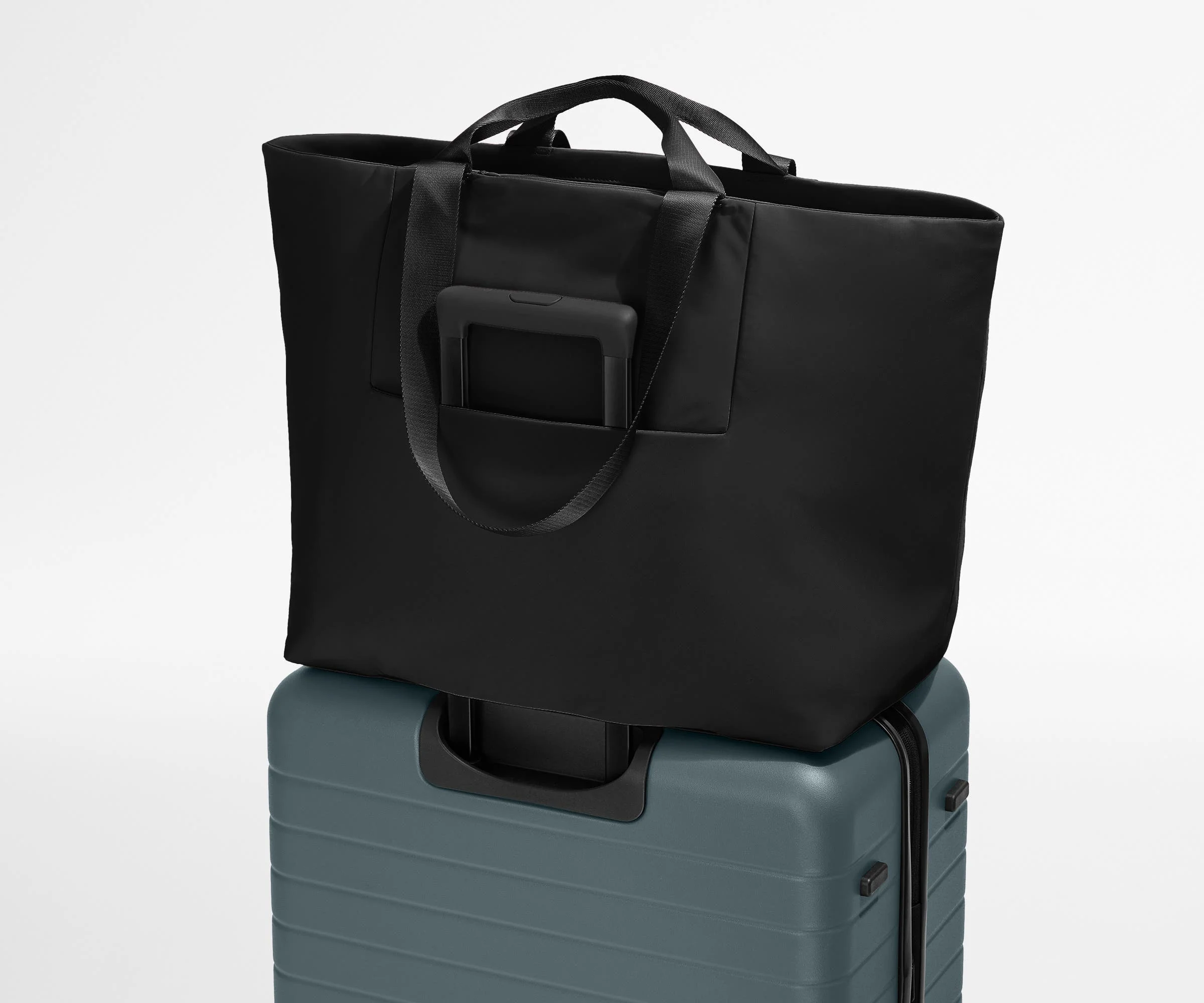 Large Featherlight Tote on top of a checked-size Away suitcase