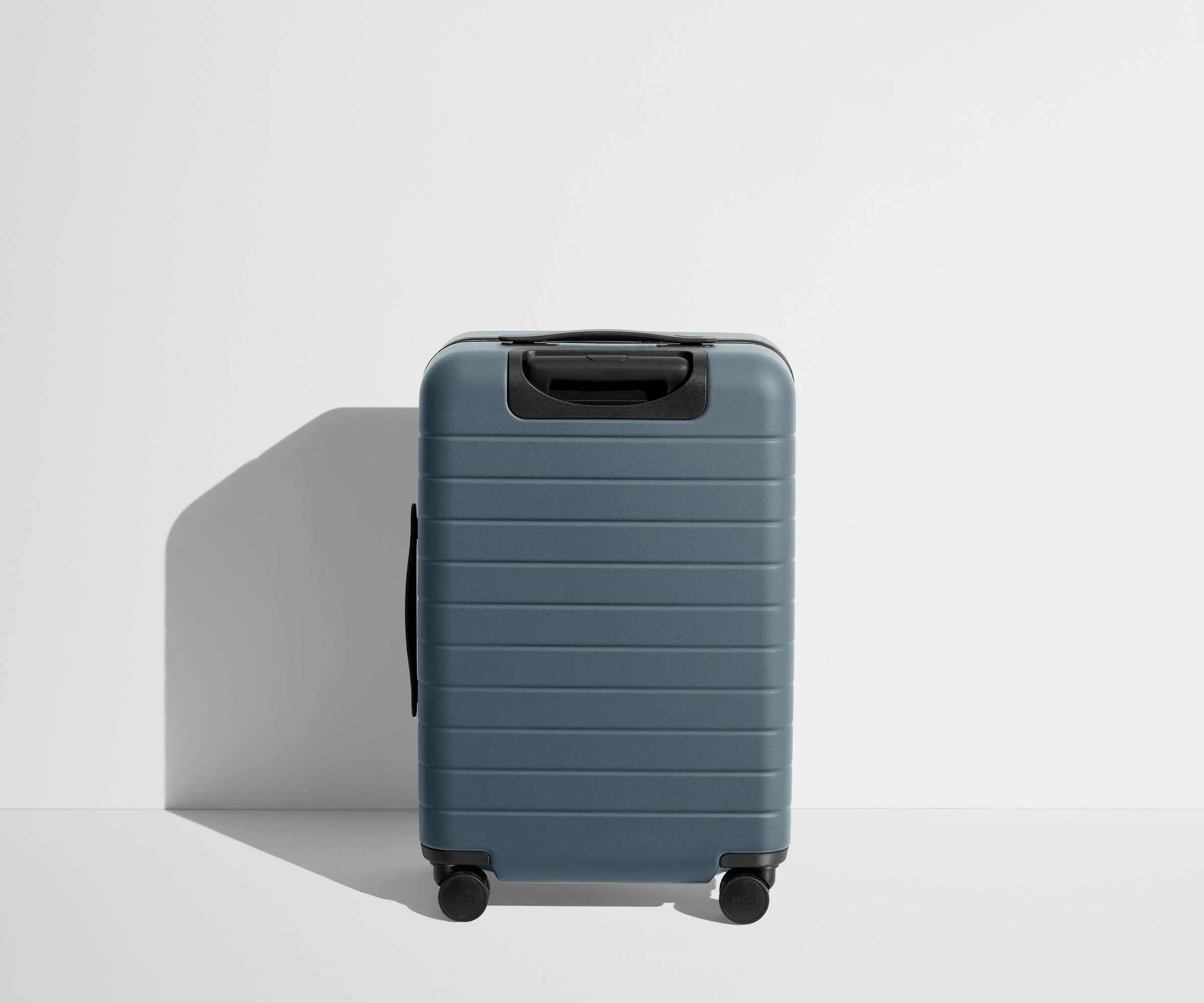 Back product view of The Bigger Carry-On suitcase in Coast Blue