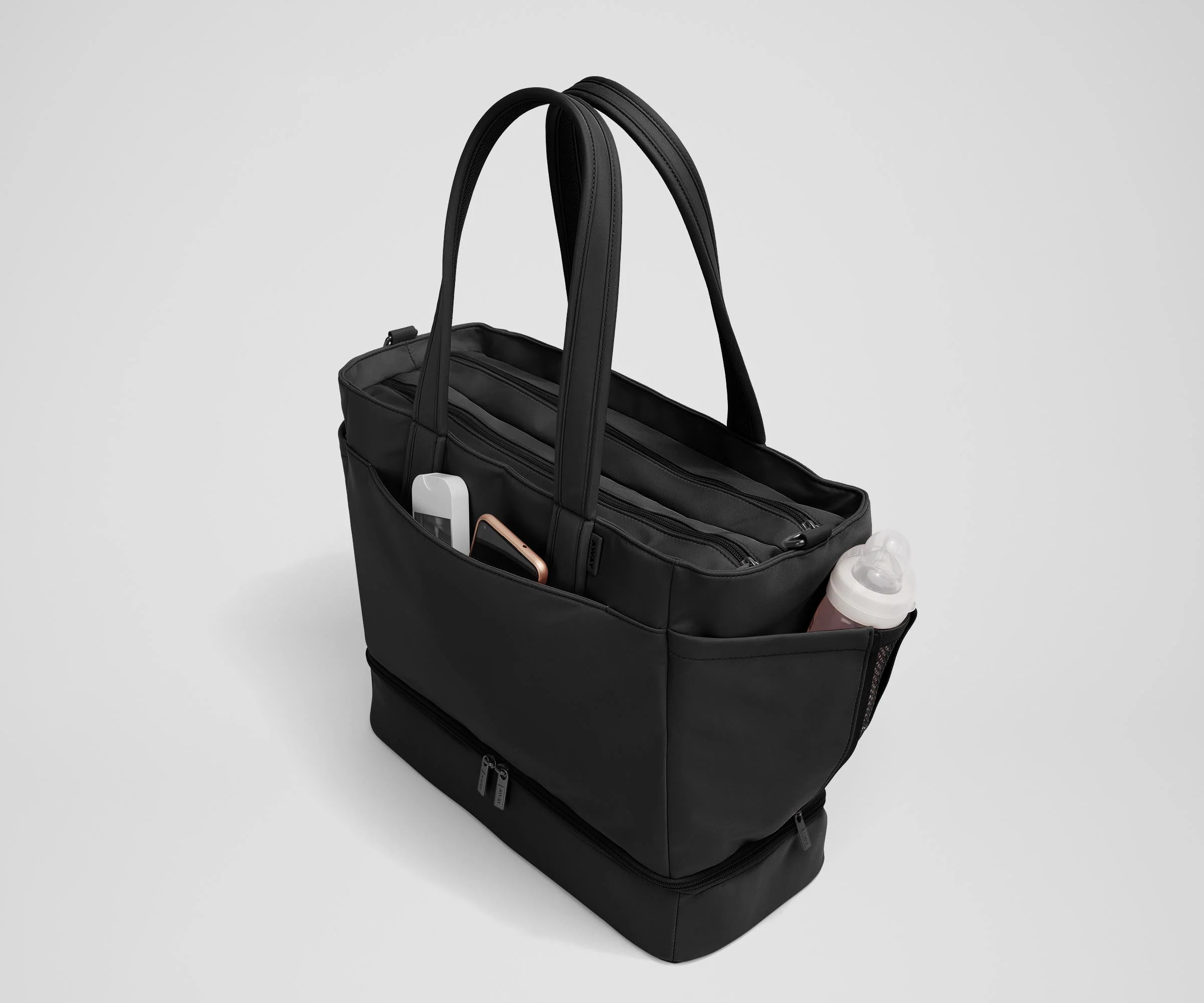 Exterior front pocket packed with hand sanitizer and a phone. Exterior bottle pocket packed with a milk bottle