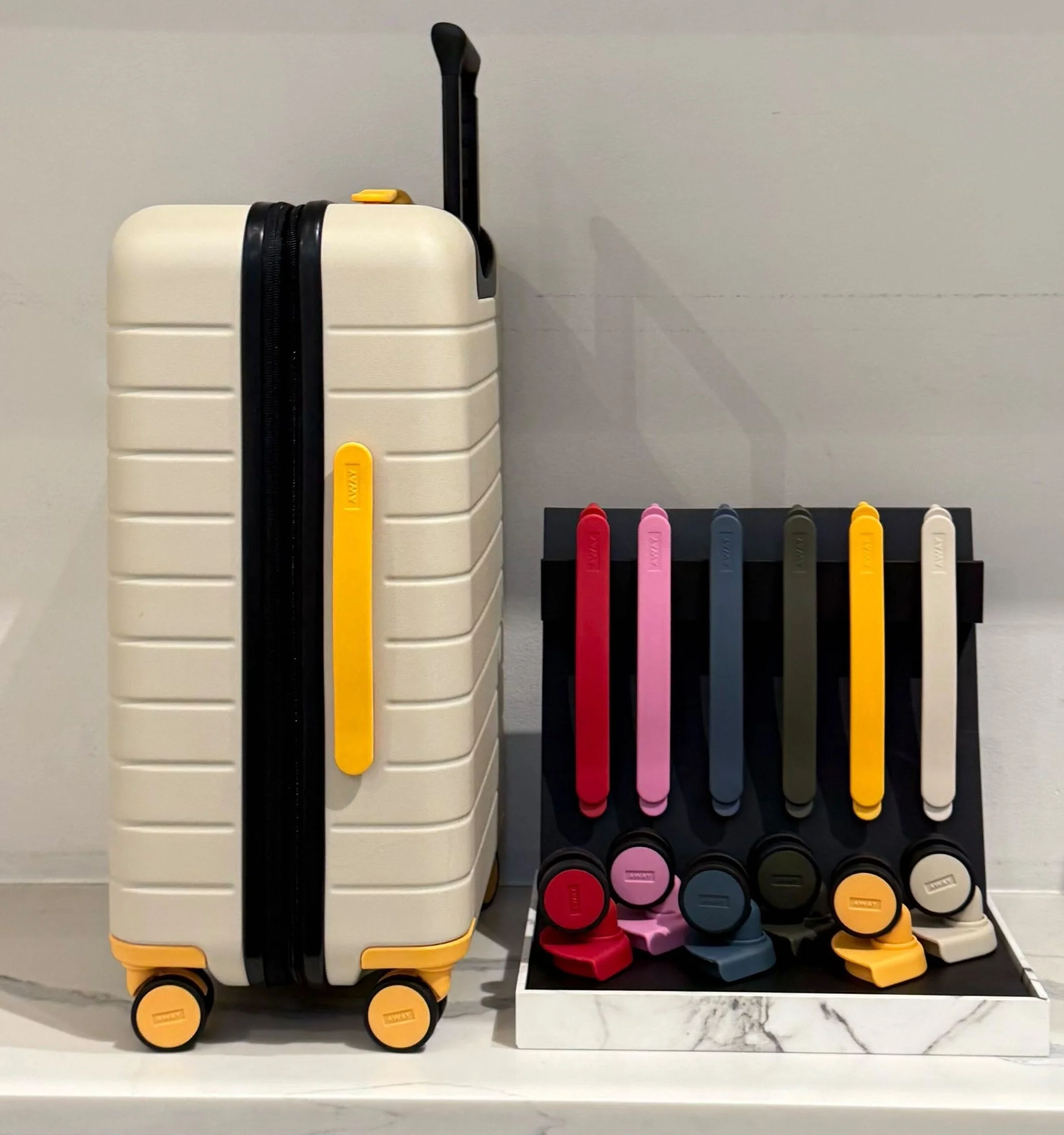 Customized white luggage with yellow wheels and handles