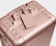Color-matching Rose Gold leather luggage tag that comes with the Aluminum suitcase