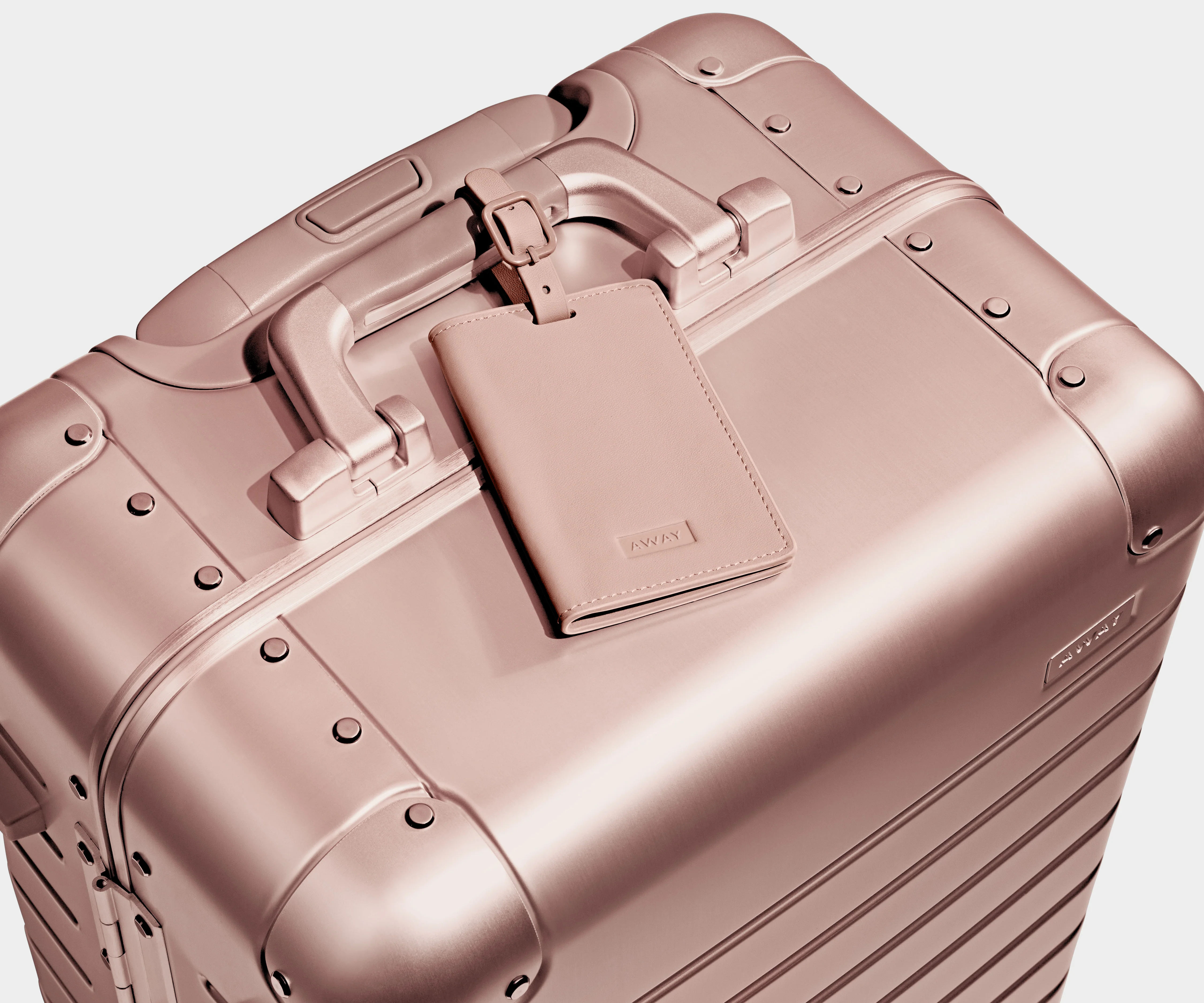 Color-matching Rose Gold leather luggage tag that comes with the Aluminum suitcase