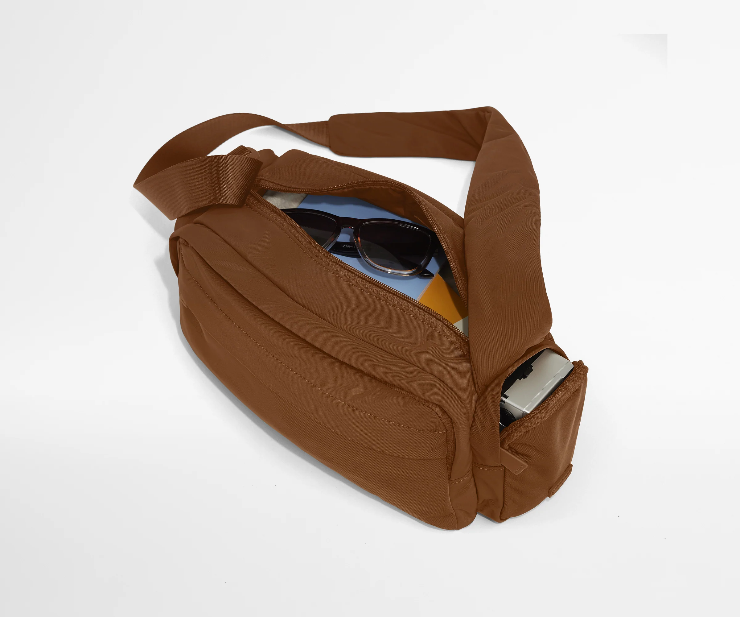 Featherlight Cargo Pack packed with notebooks, sunglasses, and a camera