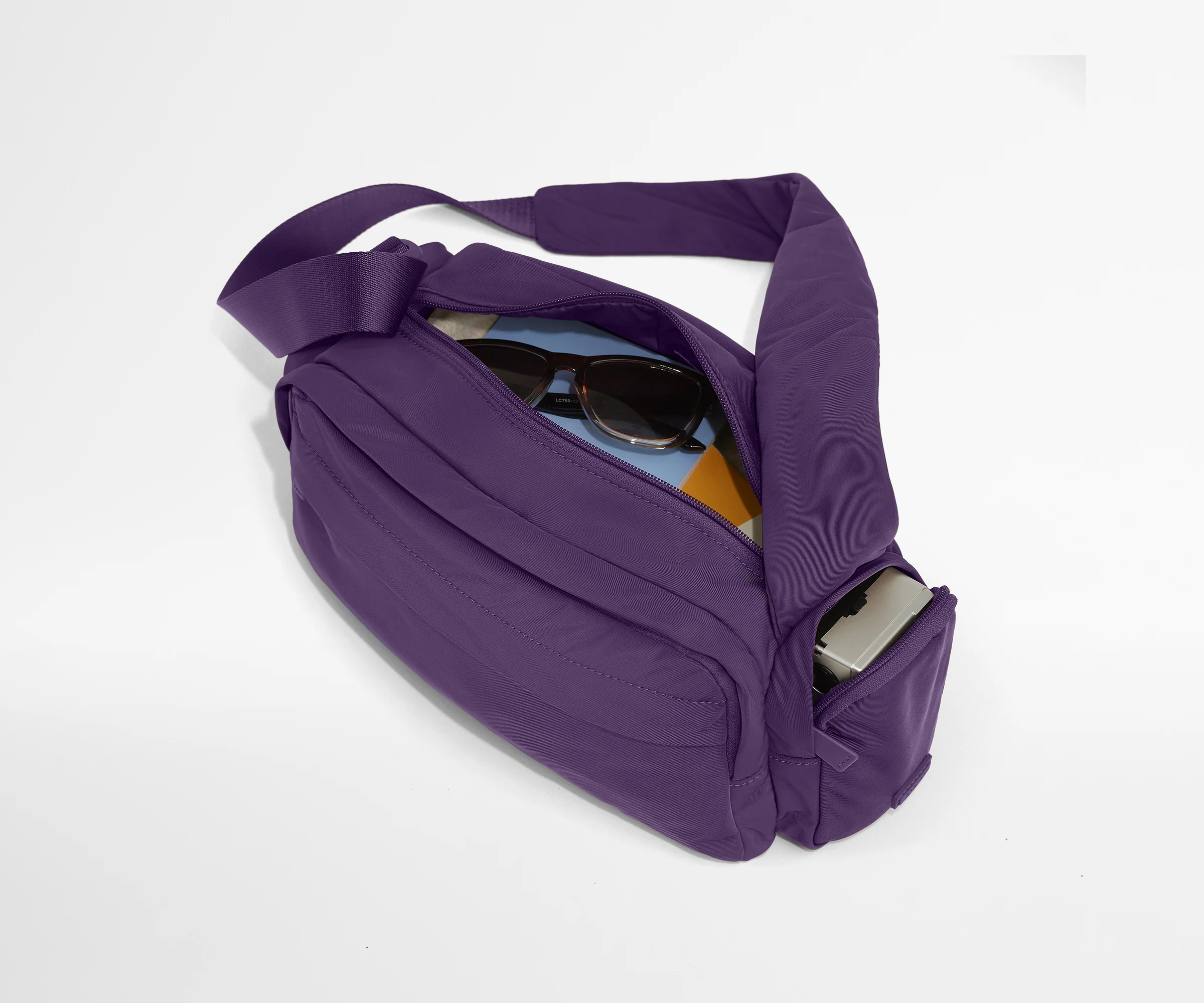 Featherlight Cargo Pack packed with notebooks, sunglasses, and a camera