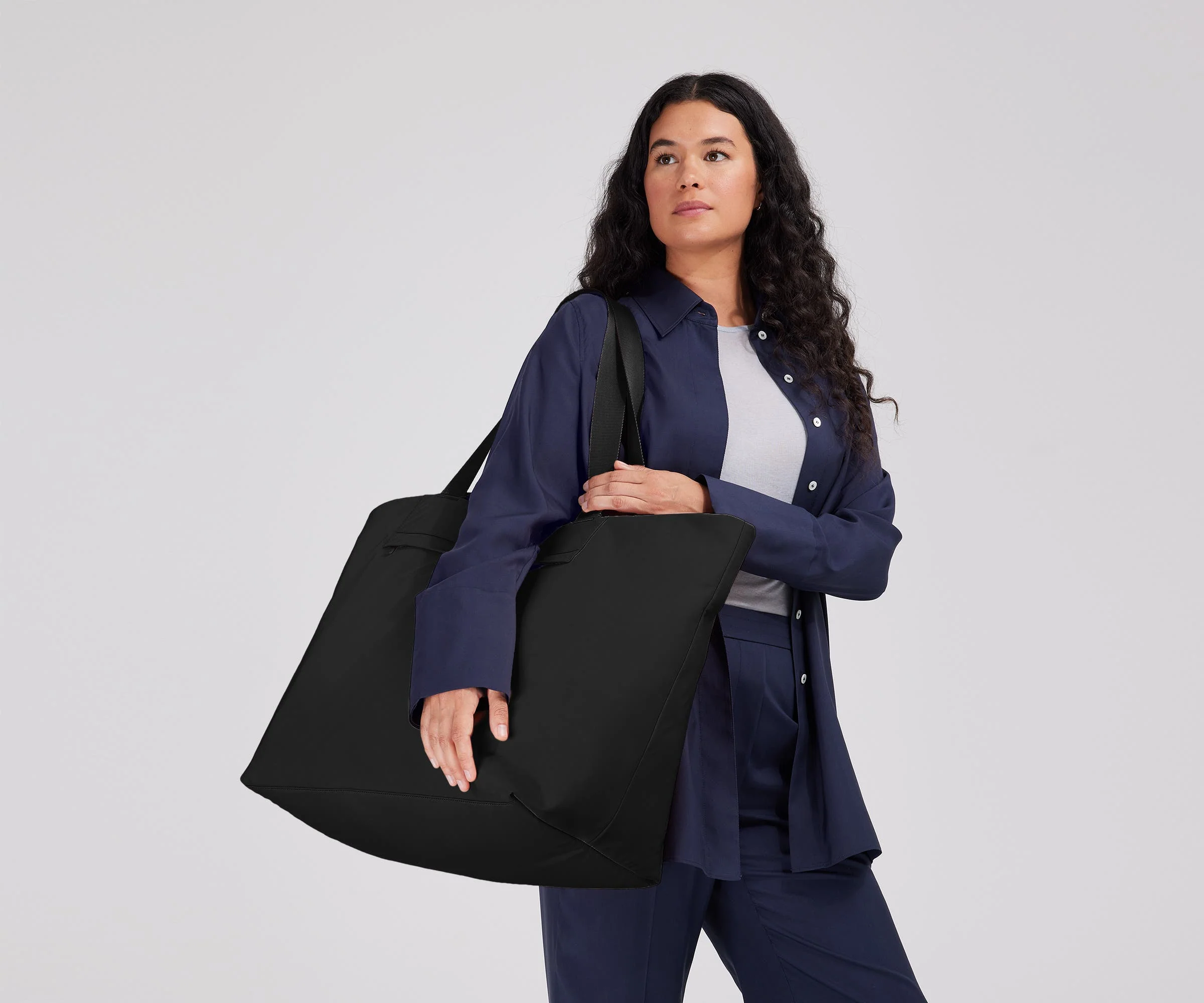 Person wearing the Large Featherlight Tote on their shoulder using the longer shoulder straps
// Model is 5'7" 