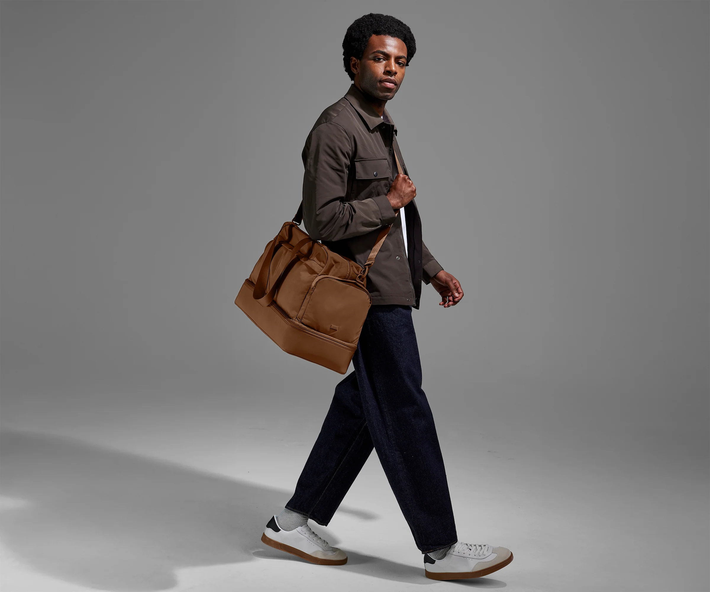 Person wearing the Featherlight Weekender as a crossbody with the detachable strap