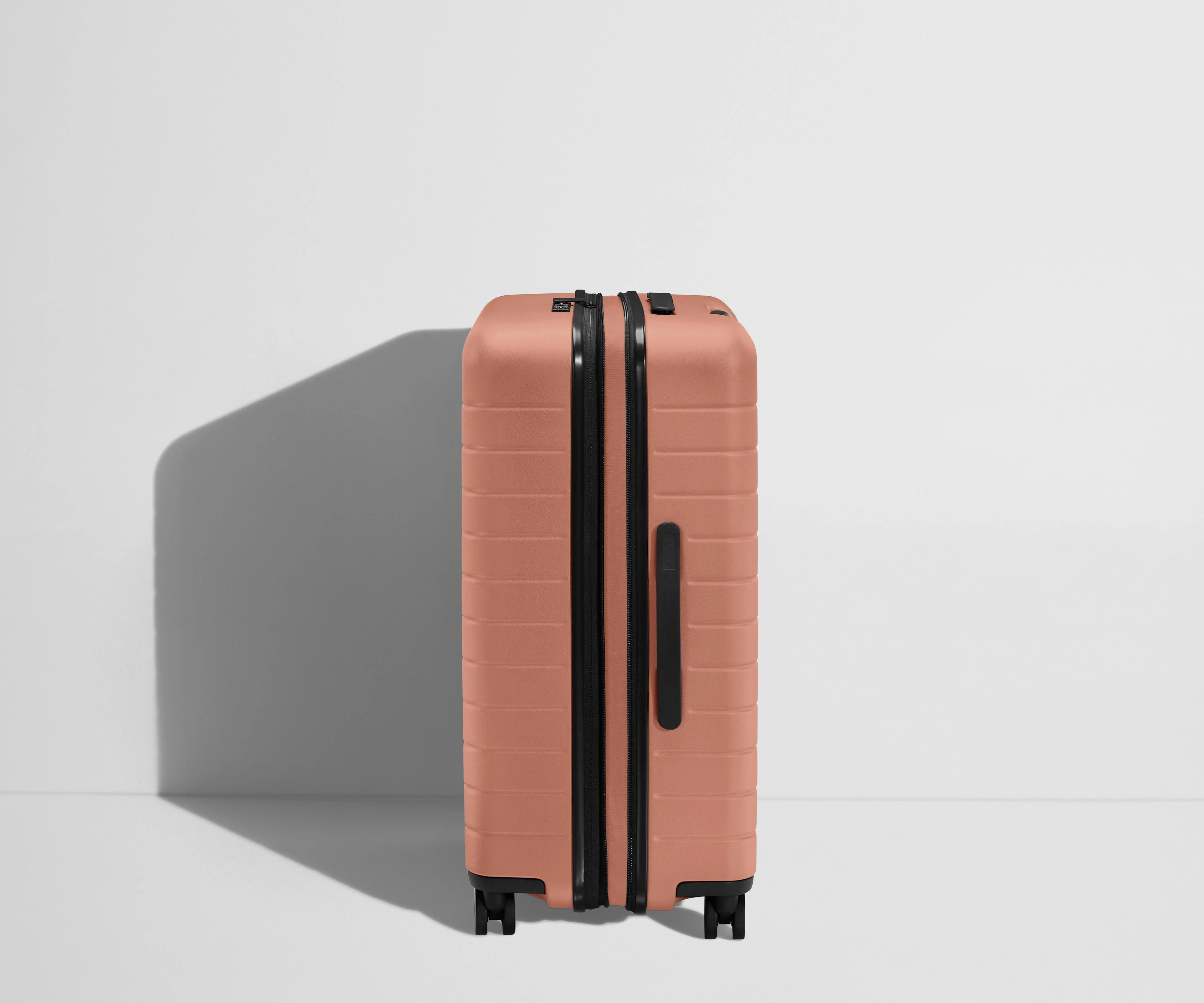 Side product view of The Medium Flex suitcase in Clay Pink shown fully expanded