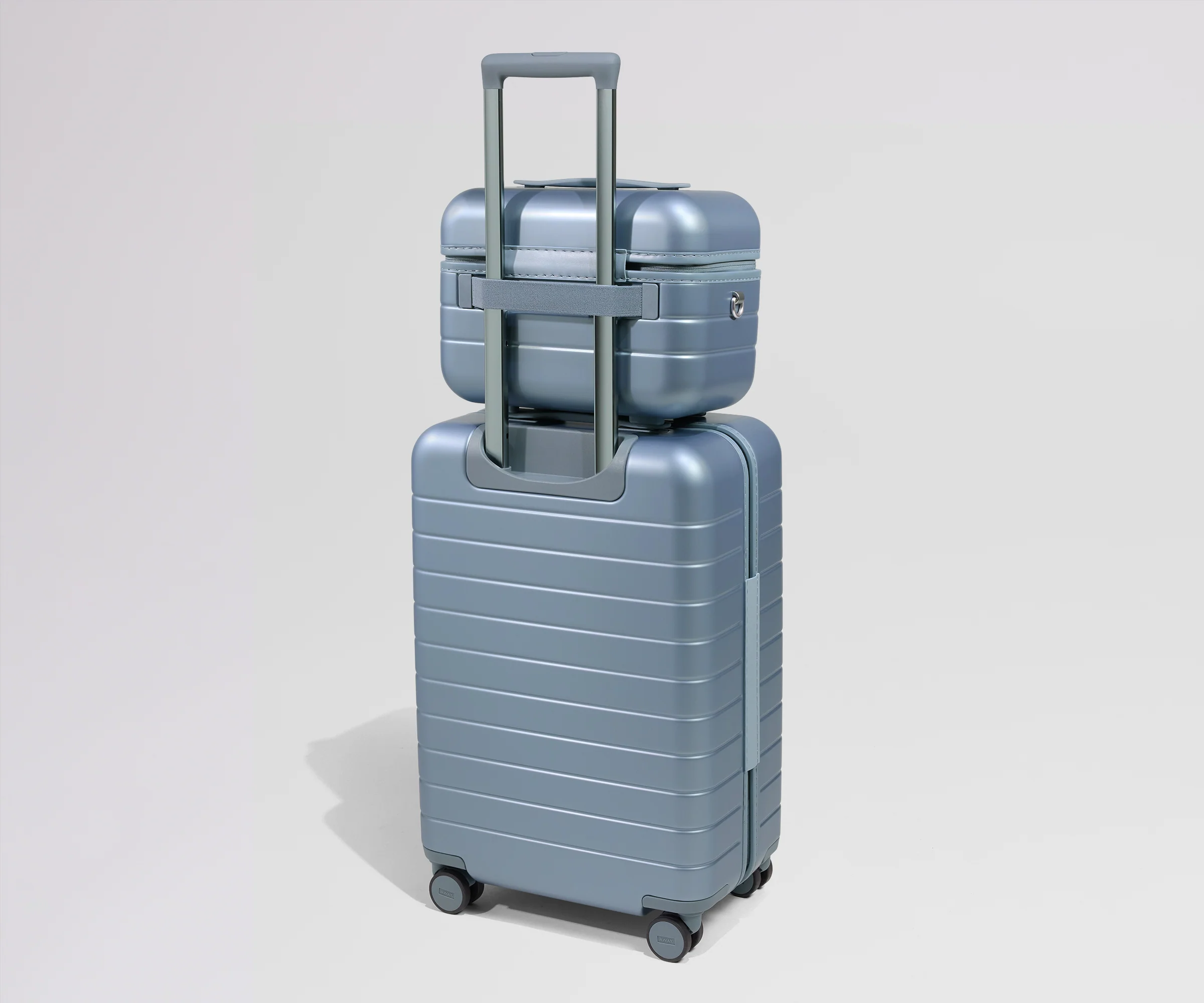 Two metallic blue suitcases stacked on a light gray background