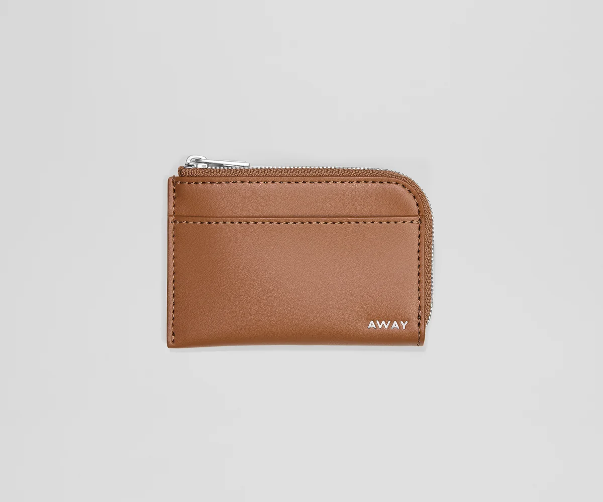 Brown leather cardholder with 'AWAY' branding on a light gray background
