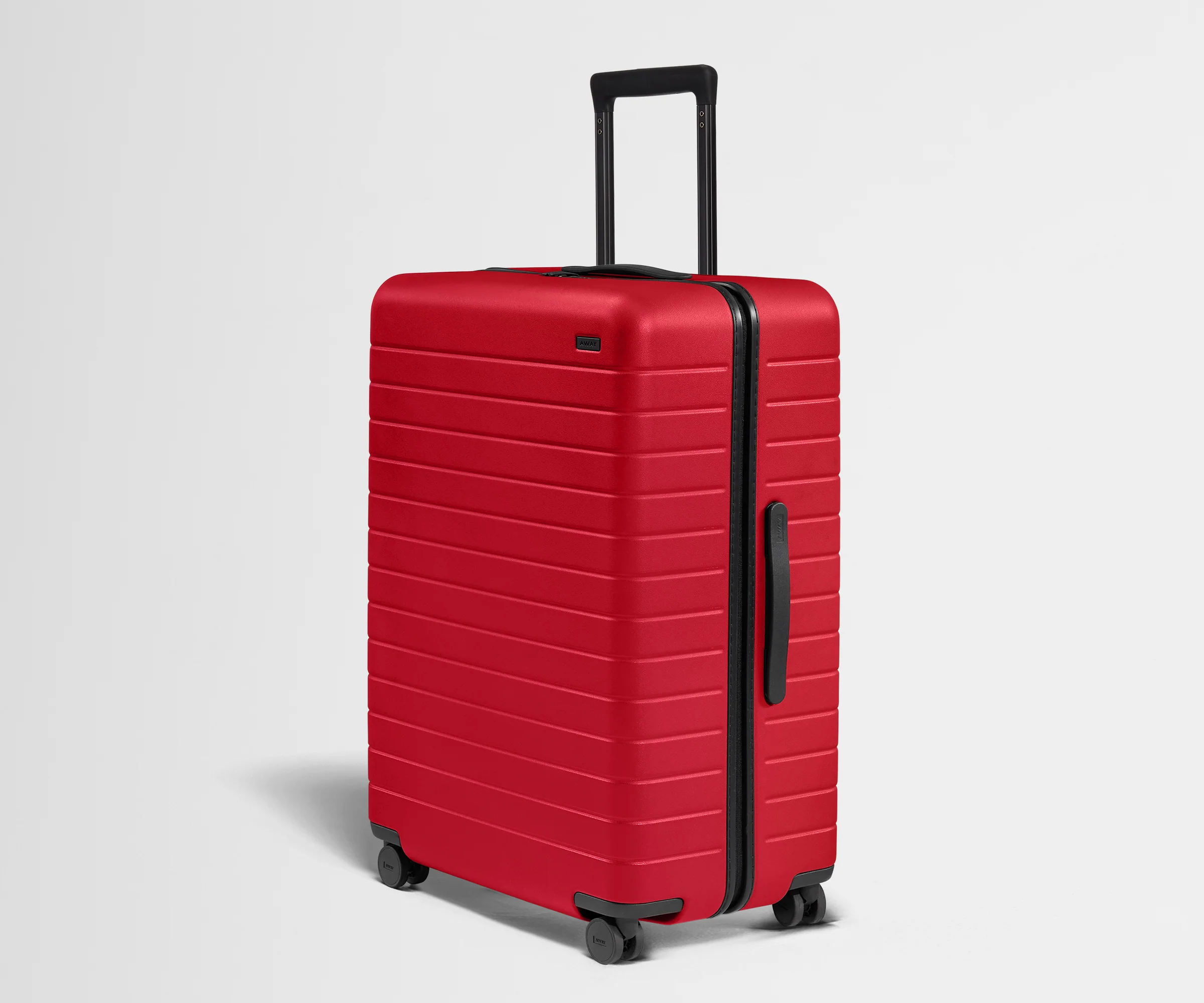 Red suitcase with black handle and wheels on a light gray background