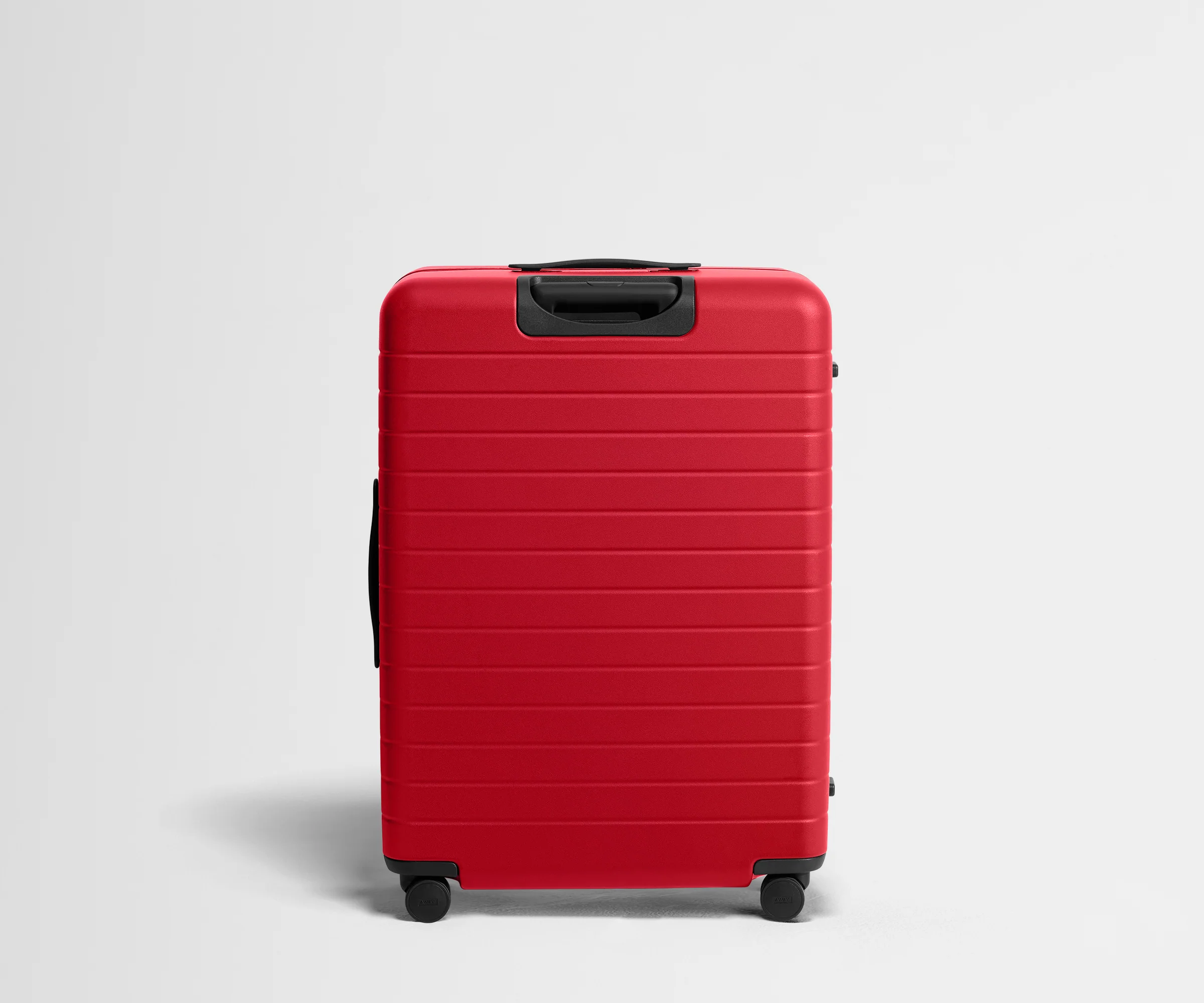 Red suitcase with black handle and wheels on a light gray background