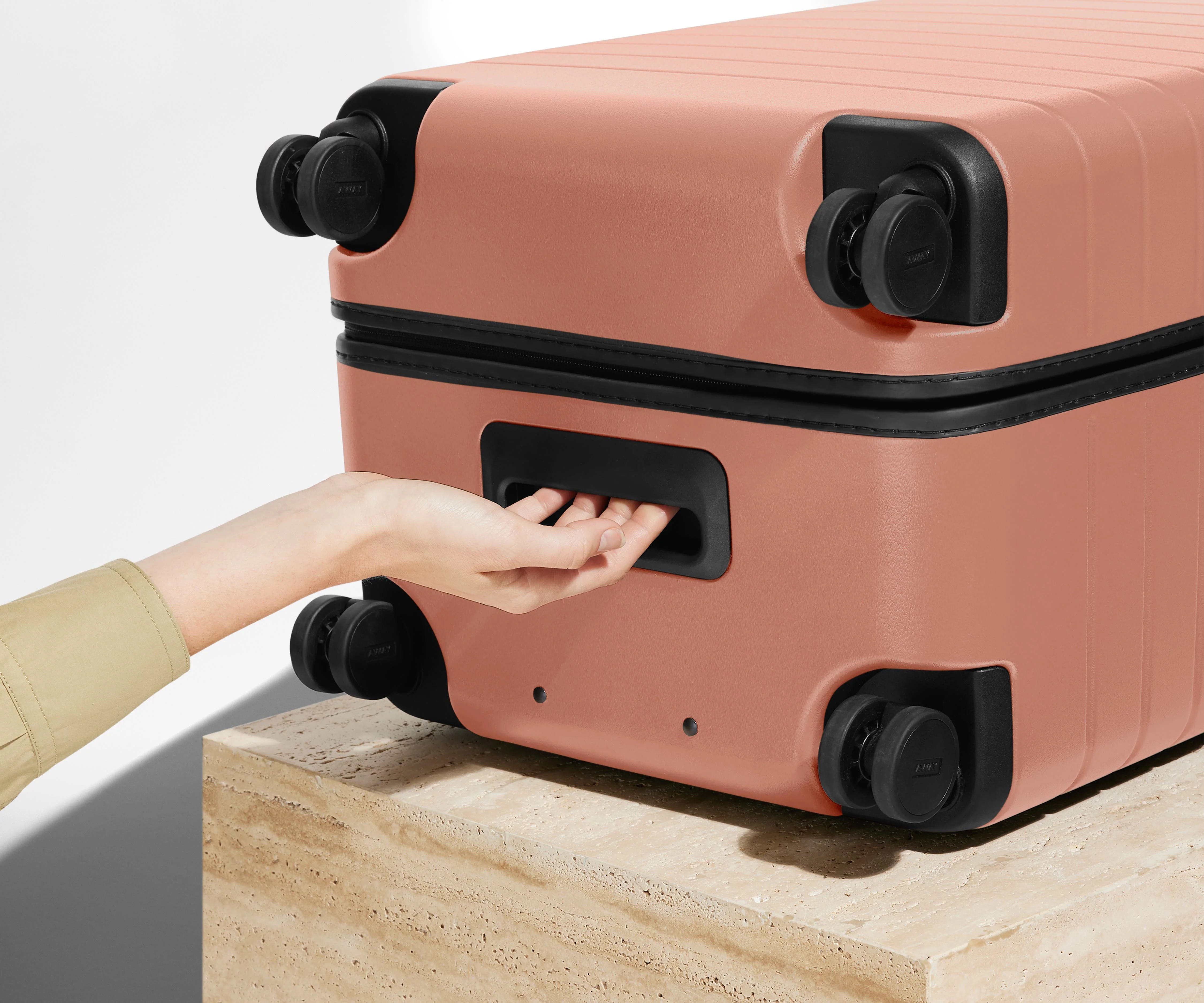 The Trunk suitcase in Clay Pink shown from below highlighting the underside grab handle