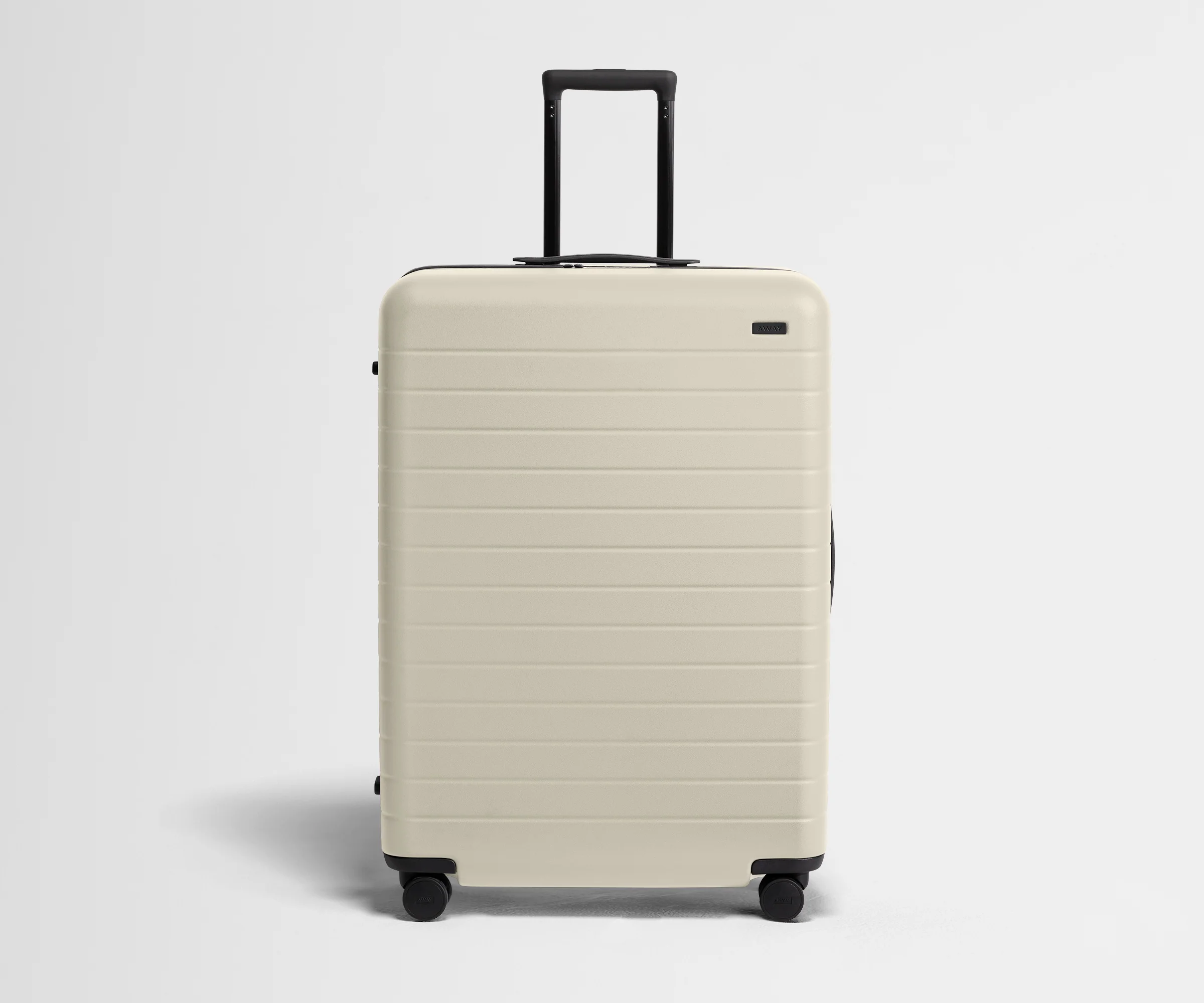 White suitcase with black handle on a light gray background