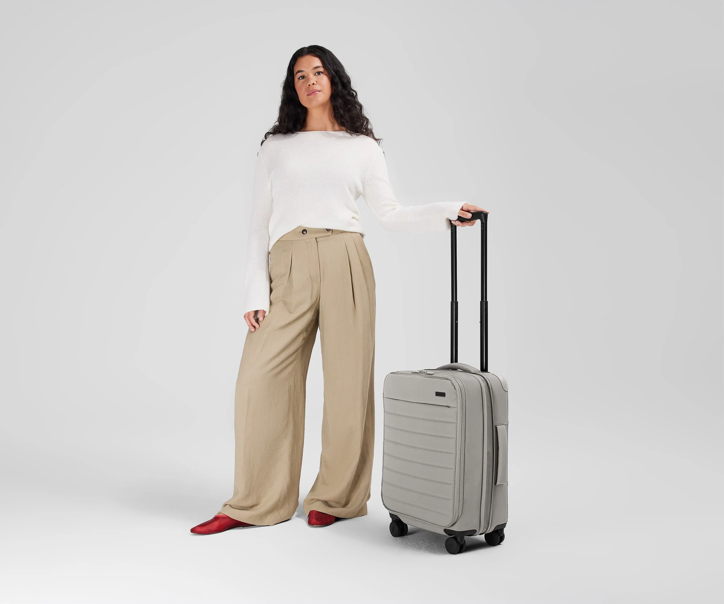 5'7" person standing next to the Softside Carry-on for scale