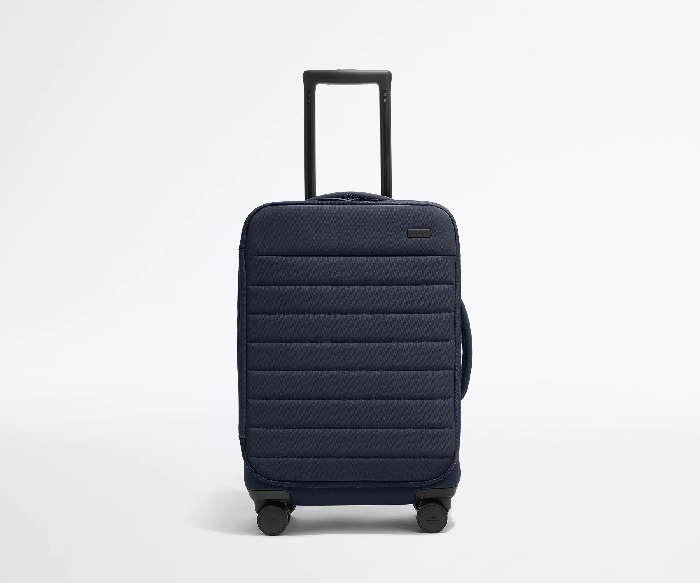 Front product view of The Softside Carry-On suitcase in Navy Blue with raised handle