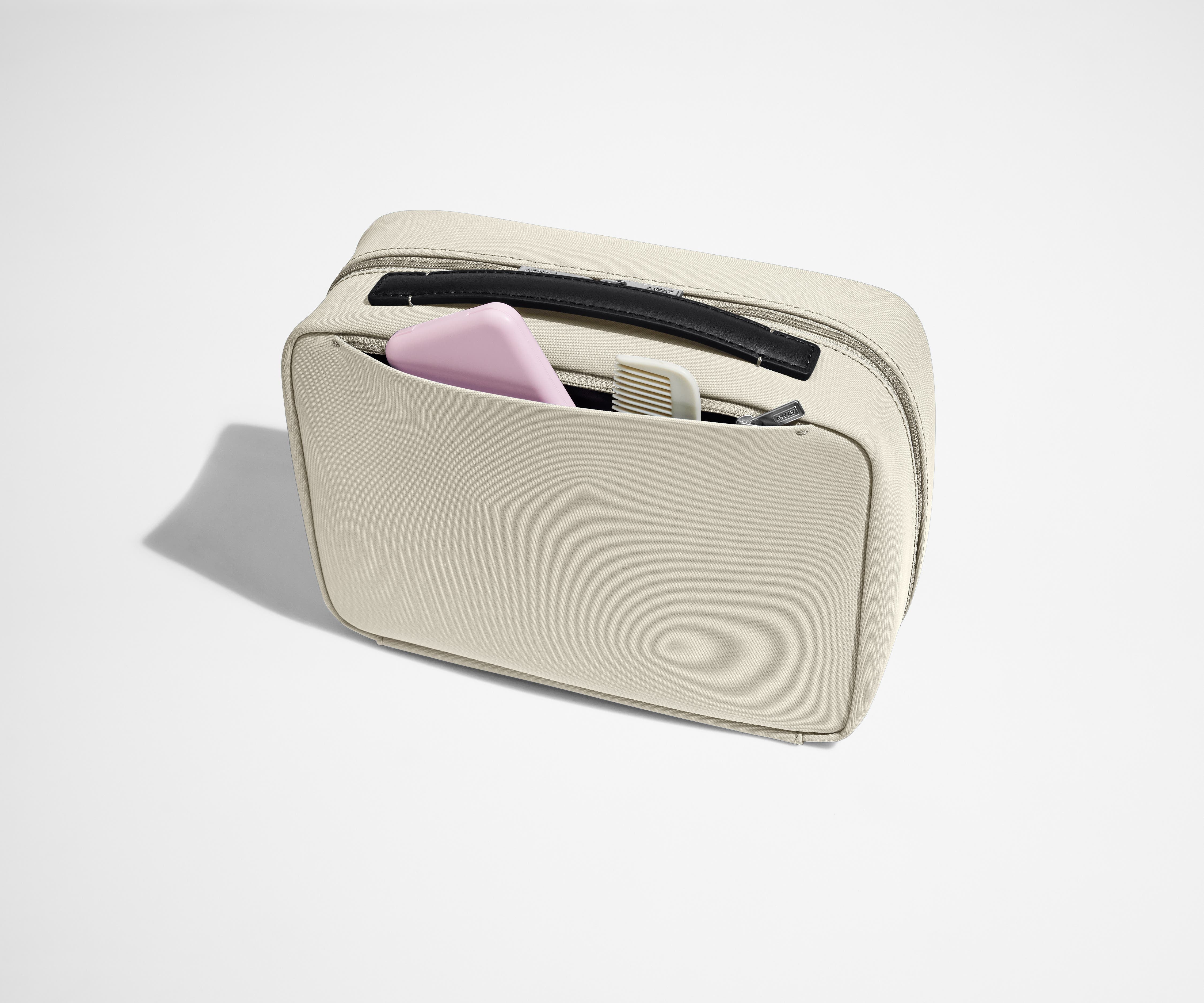 Exterior zip pocket packed with a comb and other toiletries
