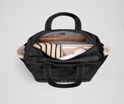 Back main compartment packed with adult travel essentials, including a laptop, notebook, and extra clothes