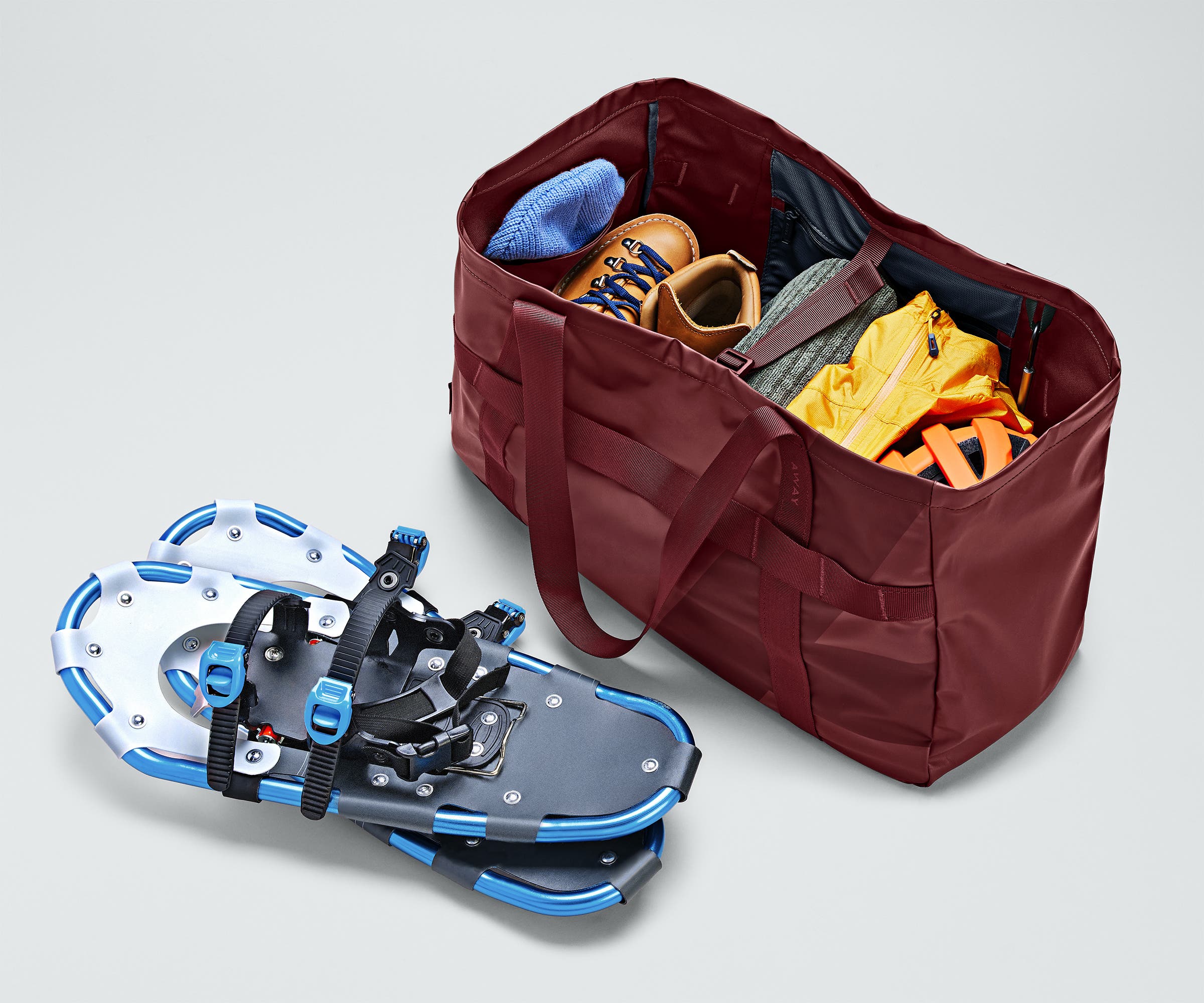 Active Tote 45L packed with clothing, hiking boots, helmet, and other outdoor gear