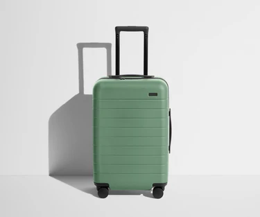 Front product view of The Carry-On suitcase in Sea Green with raised handle