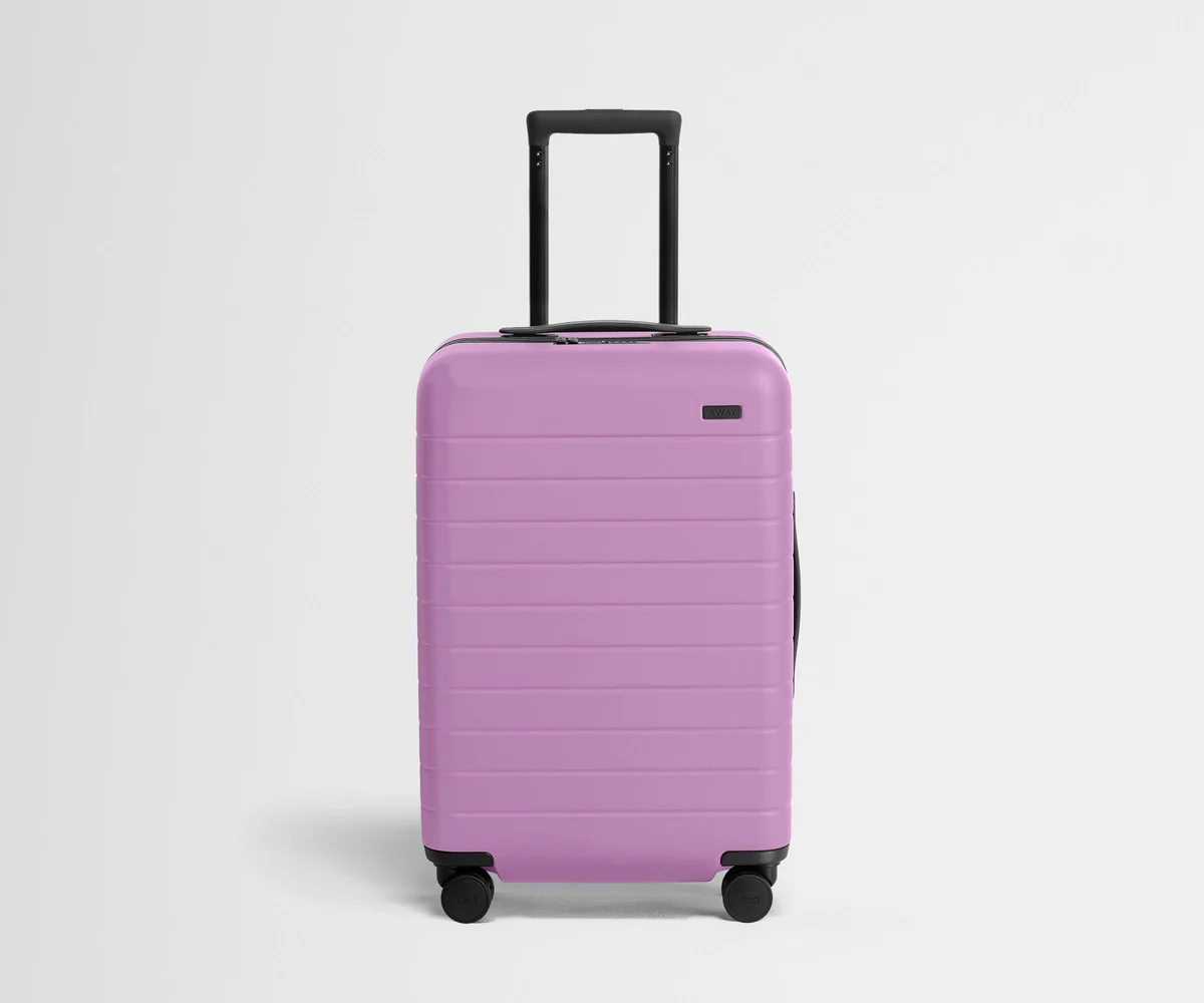 Front product view of The Bigger Carry-On suitcase in Taffy Purple with raised handle