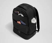 Exterior front pockets packed with travel essentials like a passport and phone, and the exterior bottle pocket packed with a milk bottle