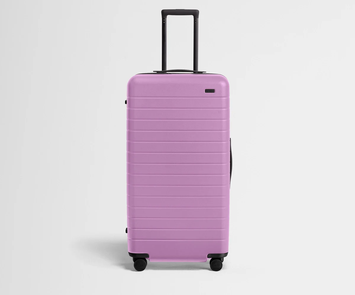 Front product view of The Trunk suitcase in Taffy Purple with raised handle