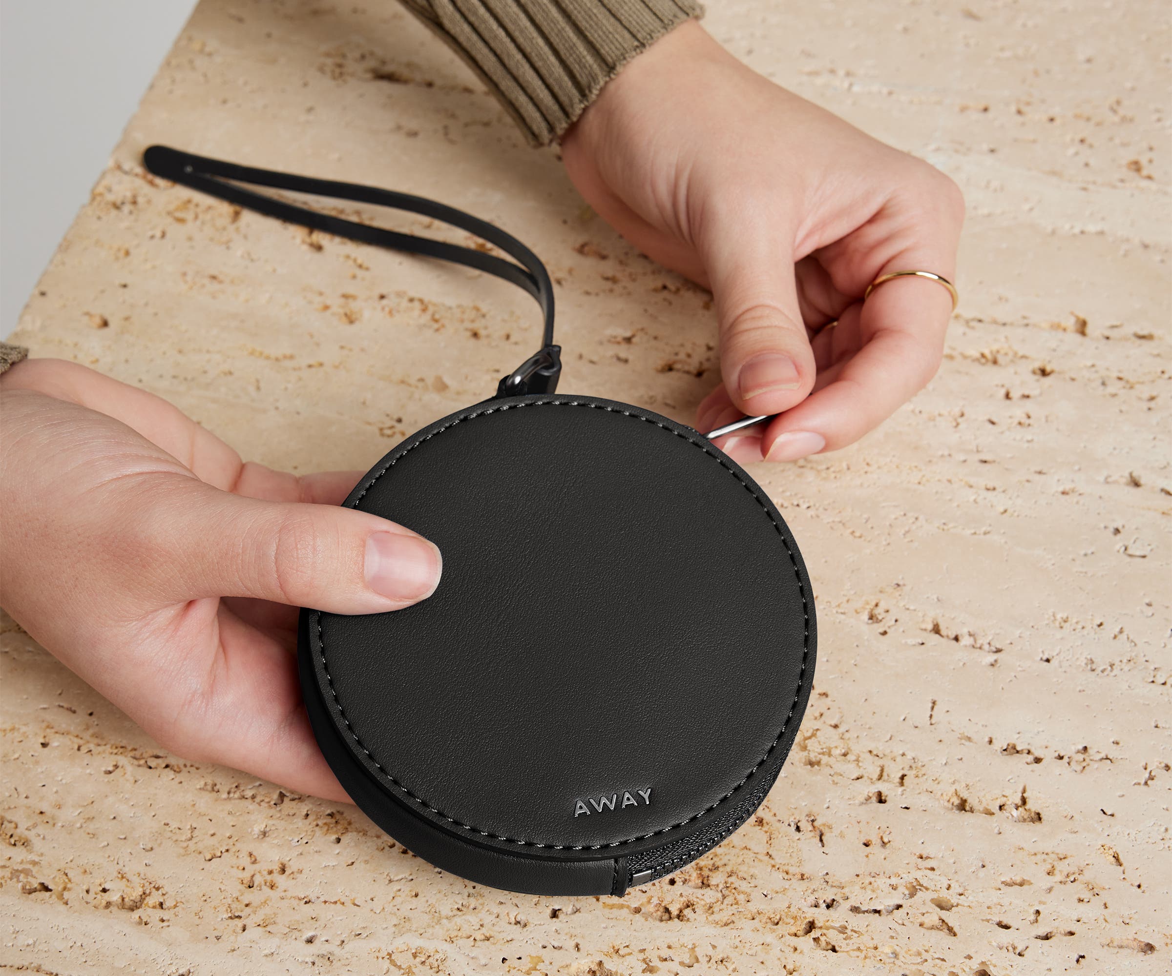 Person's hand holding the Circle Zip Pouch