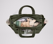 Front main compartment packed with child essentials, including a stuffed animal, wipes, and change of clothes
