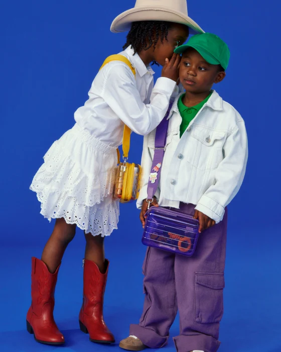 Two children in colorful outfits against a blue background